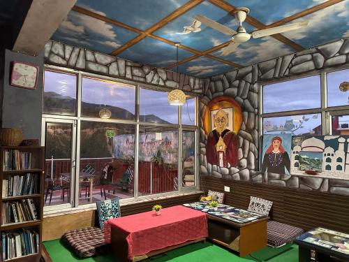 The hand-painted common room at Backpackers Inn — stone-textured walls, sky mural ceiling, and bookshelves