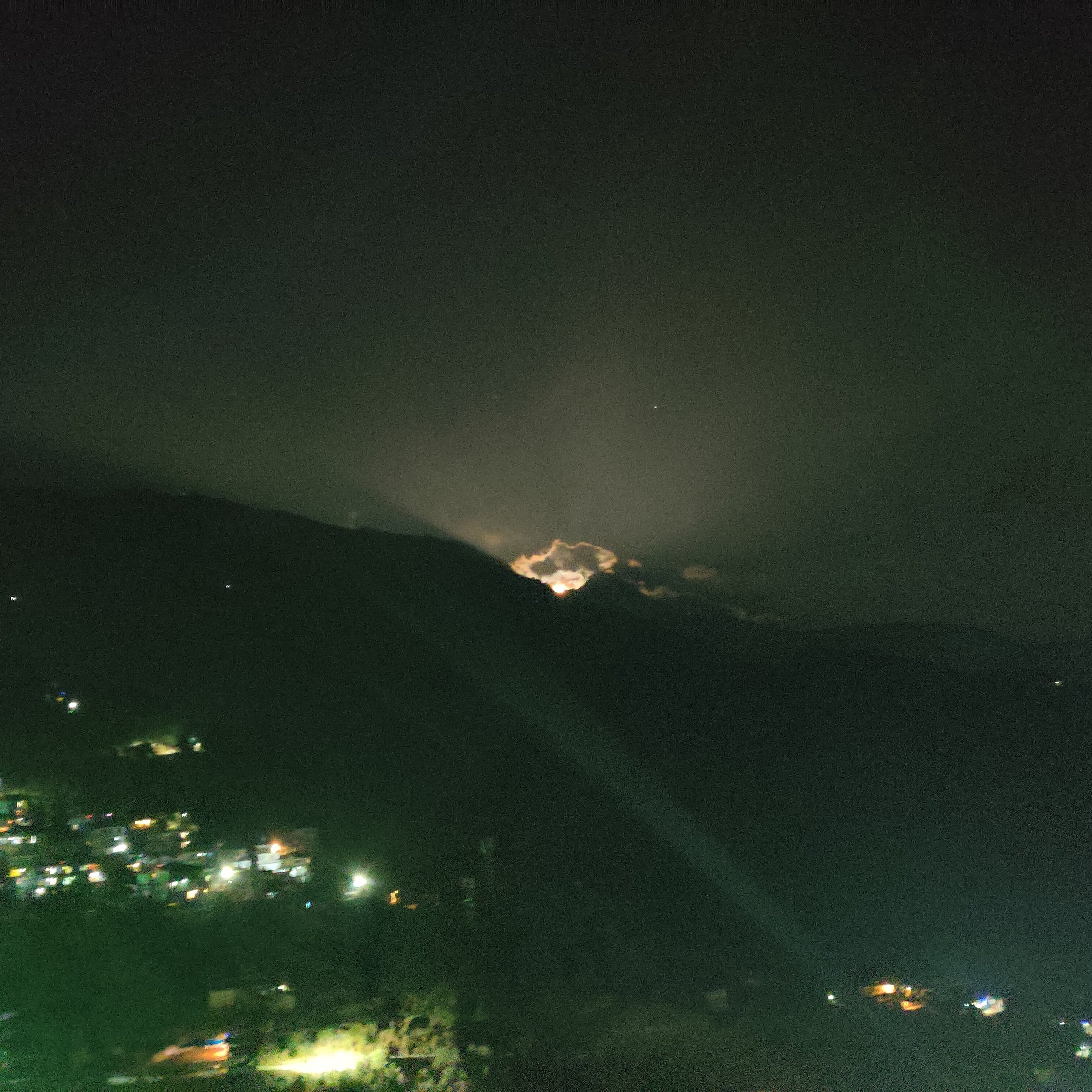 Night view of McLeod Ganj lights glowing against dark mountain silhouettes
